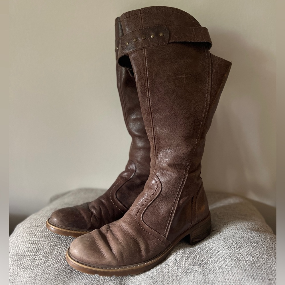 Knee high brown boots with low heel. Ridding style.